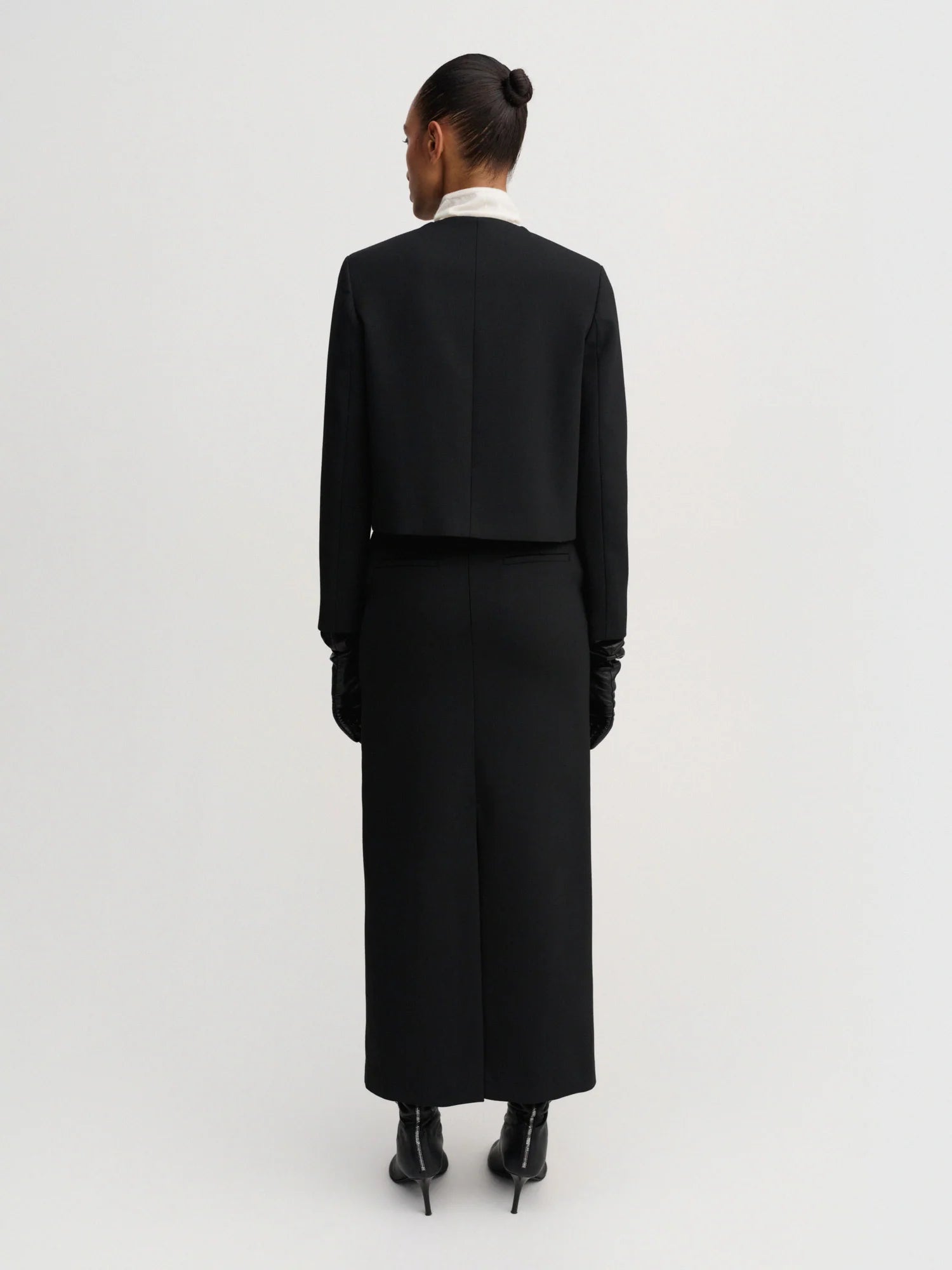 Person wearing a black coat on a white background