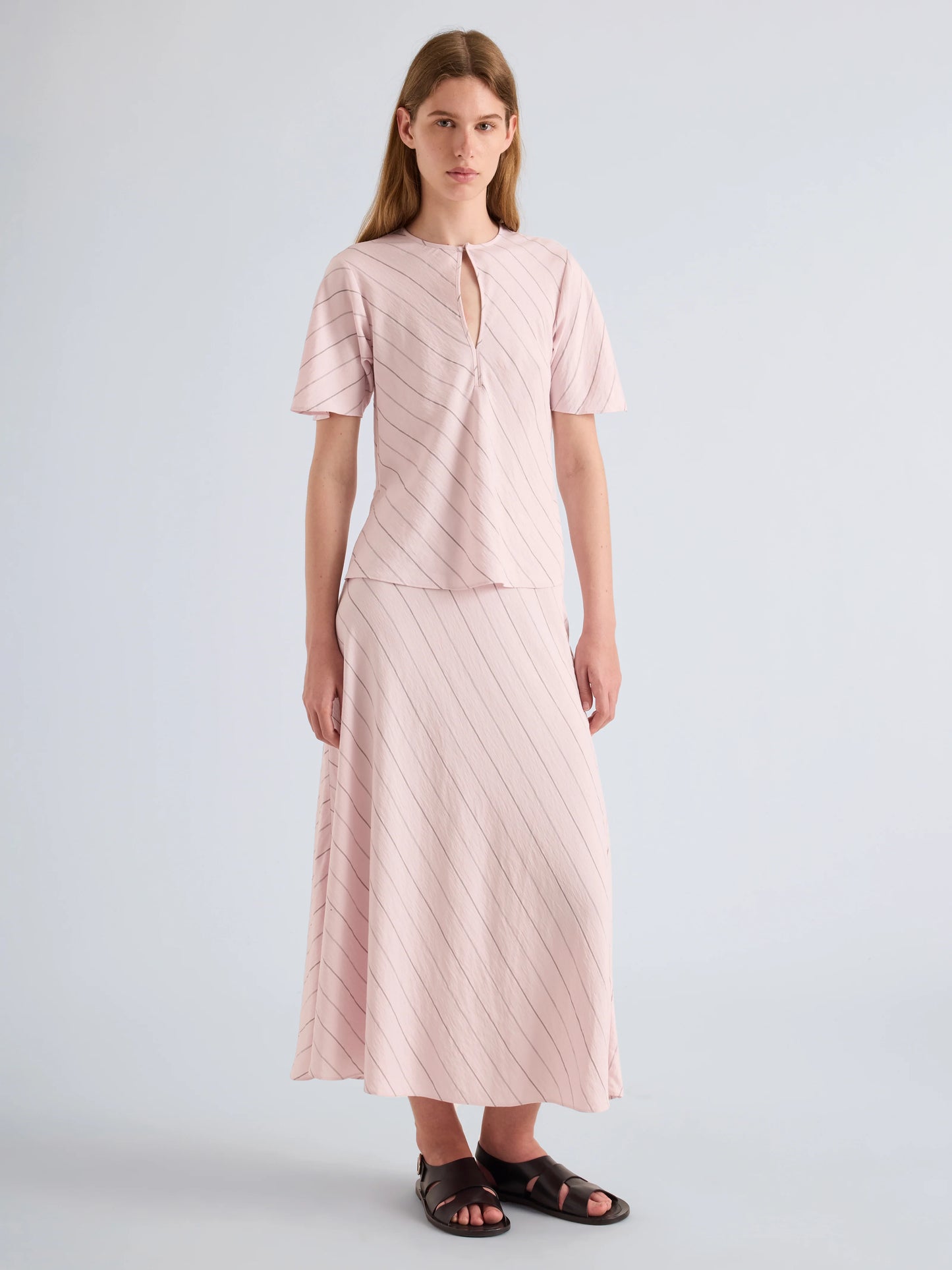 Woman wearing a pink outfit with a plain background