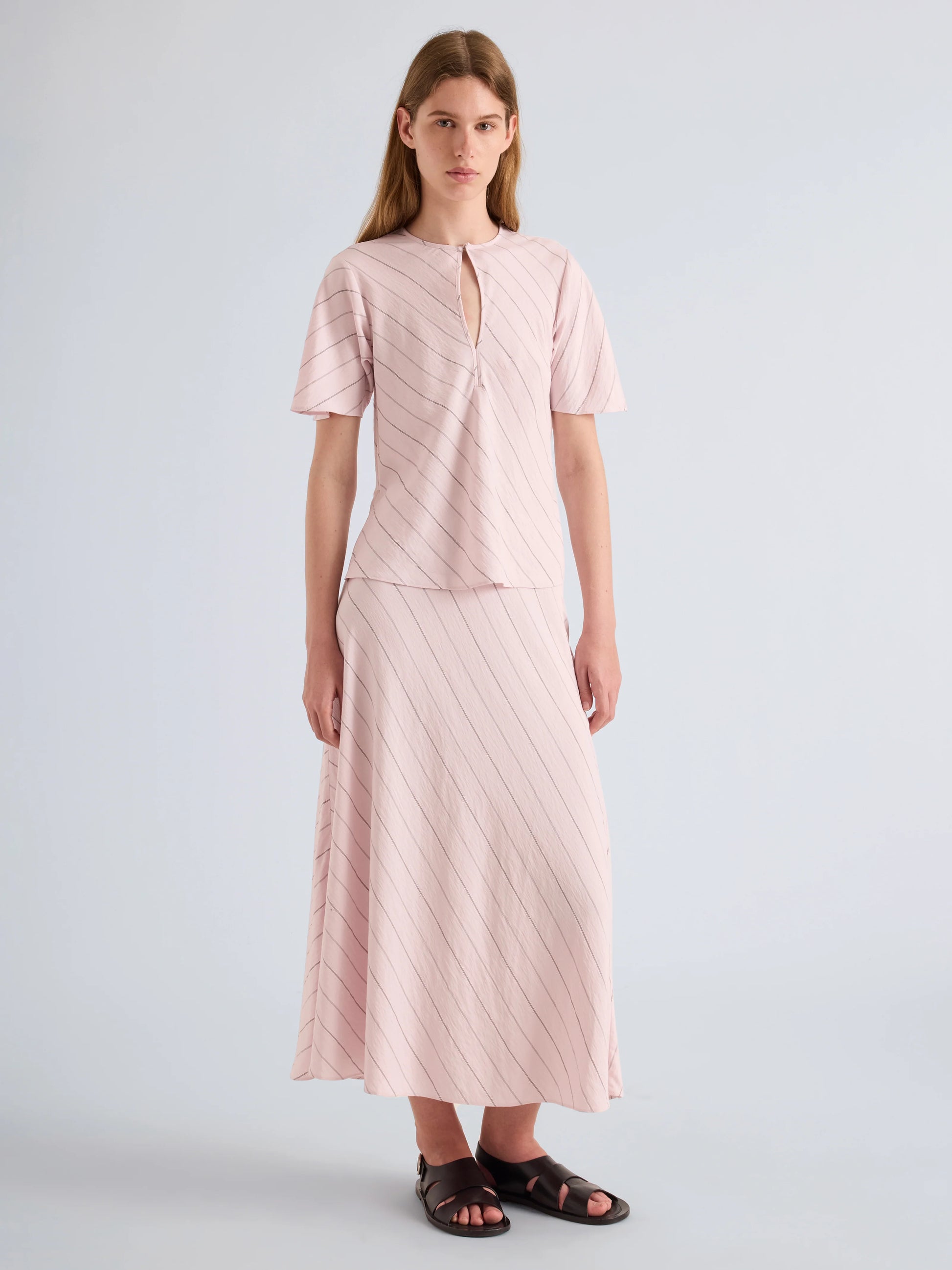 Woman wearing a pink outfit with a plain background