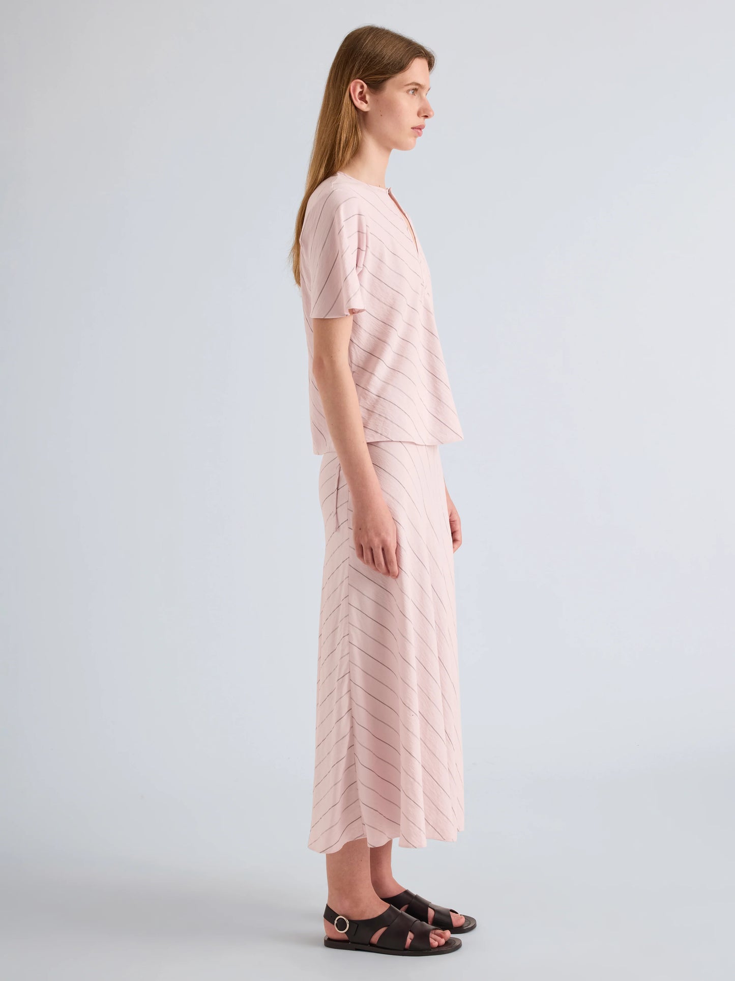 Woman wearing a light pink outfit on a plain background