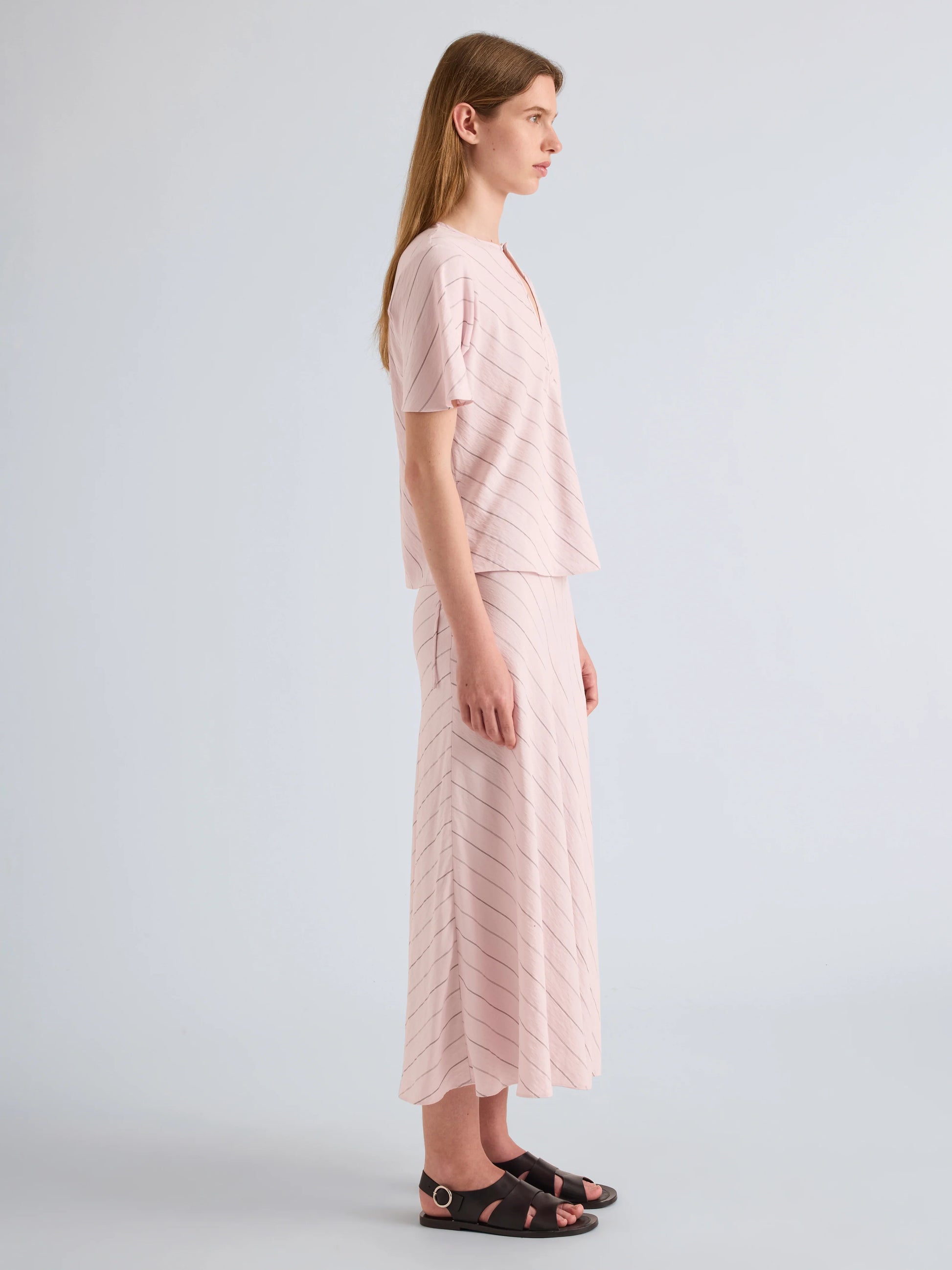 Woman wearing a light pink outfit on a plain background
