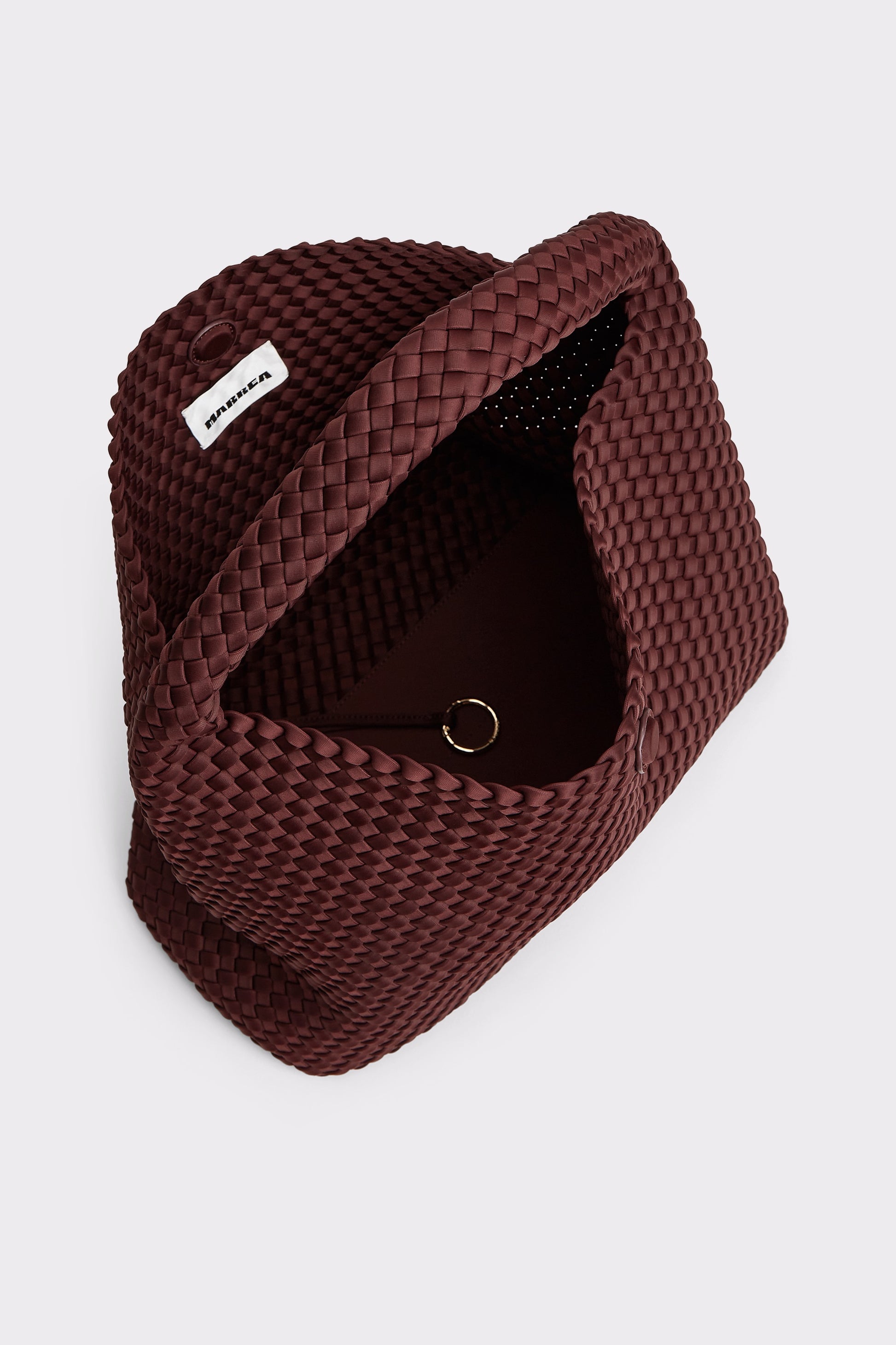 A dark burgundy woven leather clutch bag with a top handle, shown from an overhead angle on a light gray background. A small white brand tag reading 'BONIA' is visible on the upper left side.