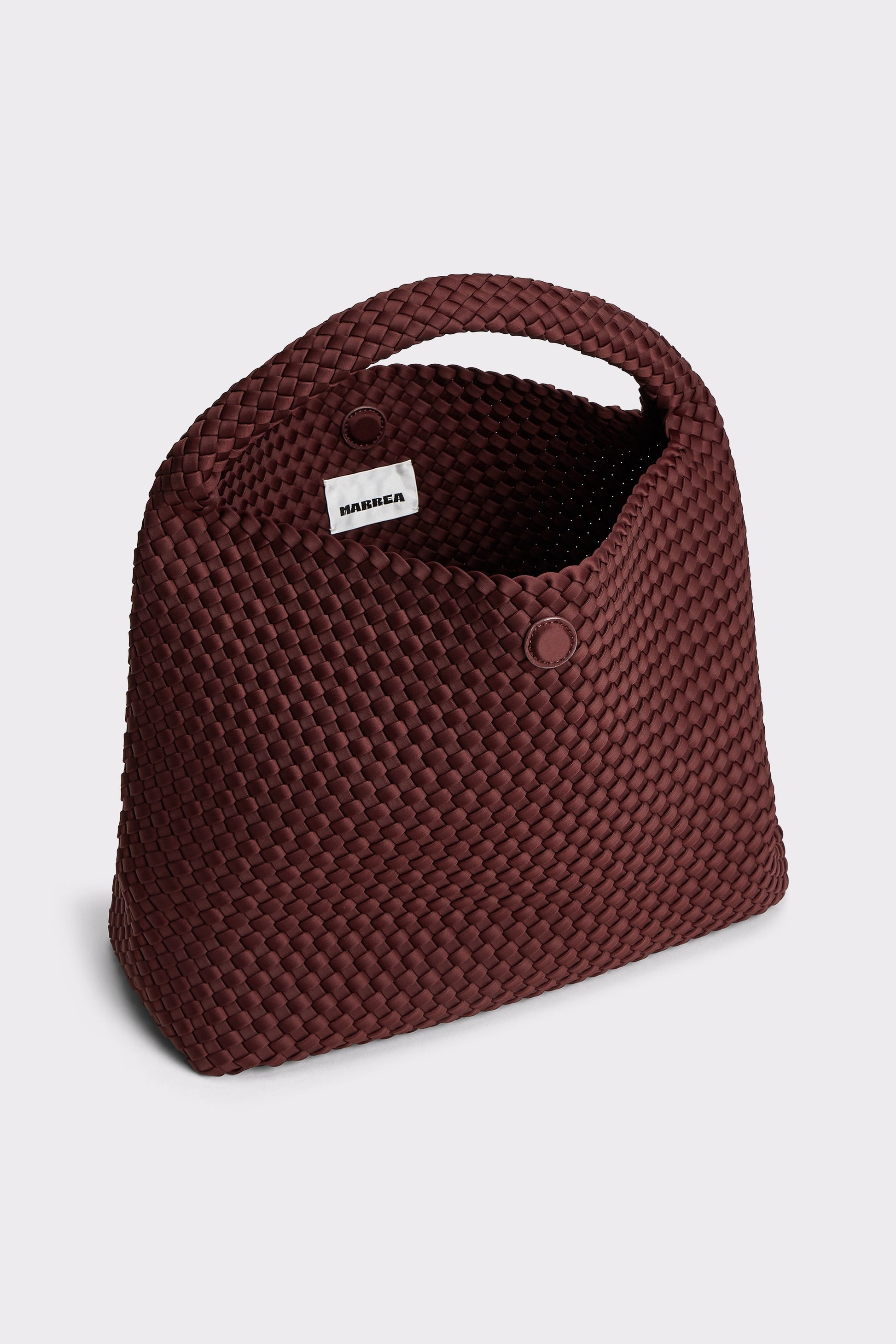 A dark burgundy woven mesh handbag with a top handle and a small white brand tag reading 'RIMMEL' on a light gray background.