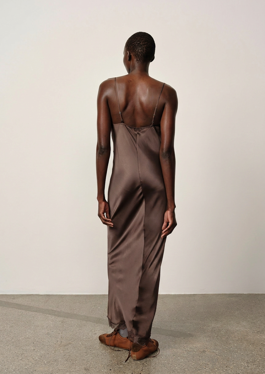 Person wearing a brown satin jumpsuit against a plain background