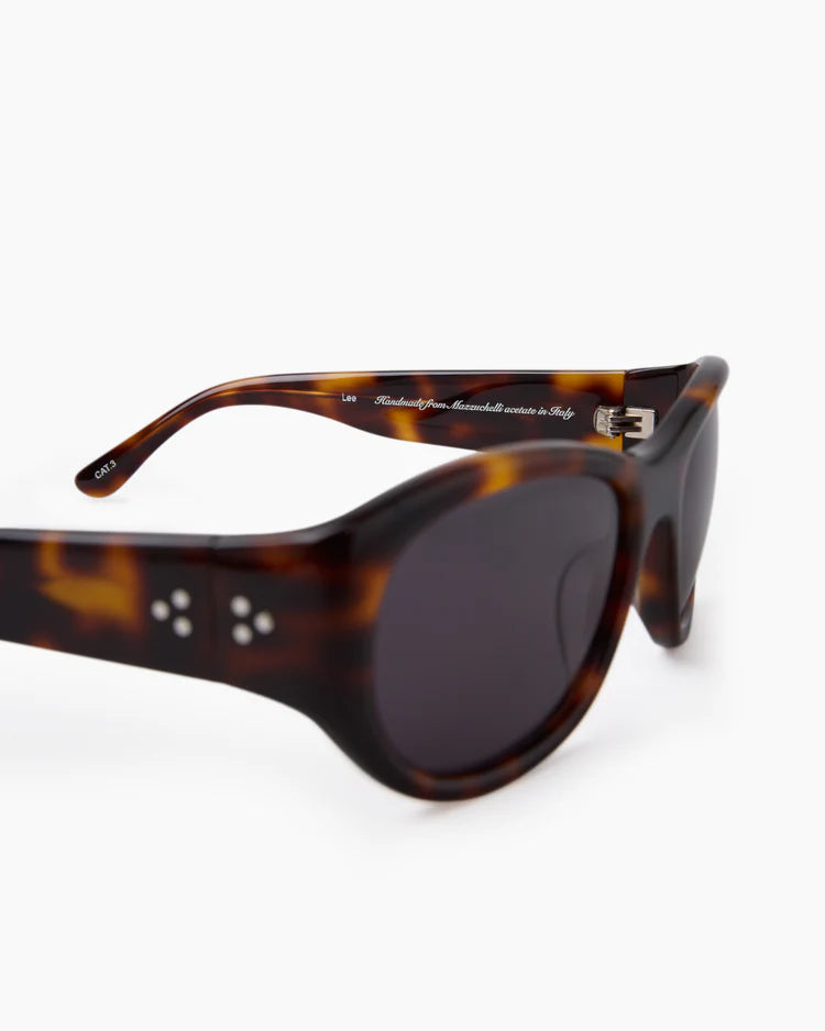 Sunglasses with tortoiseshell frame and dark lenses on a white background