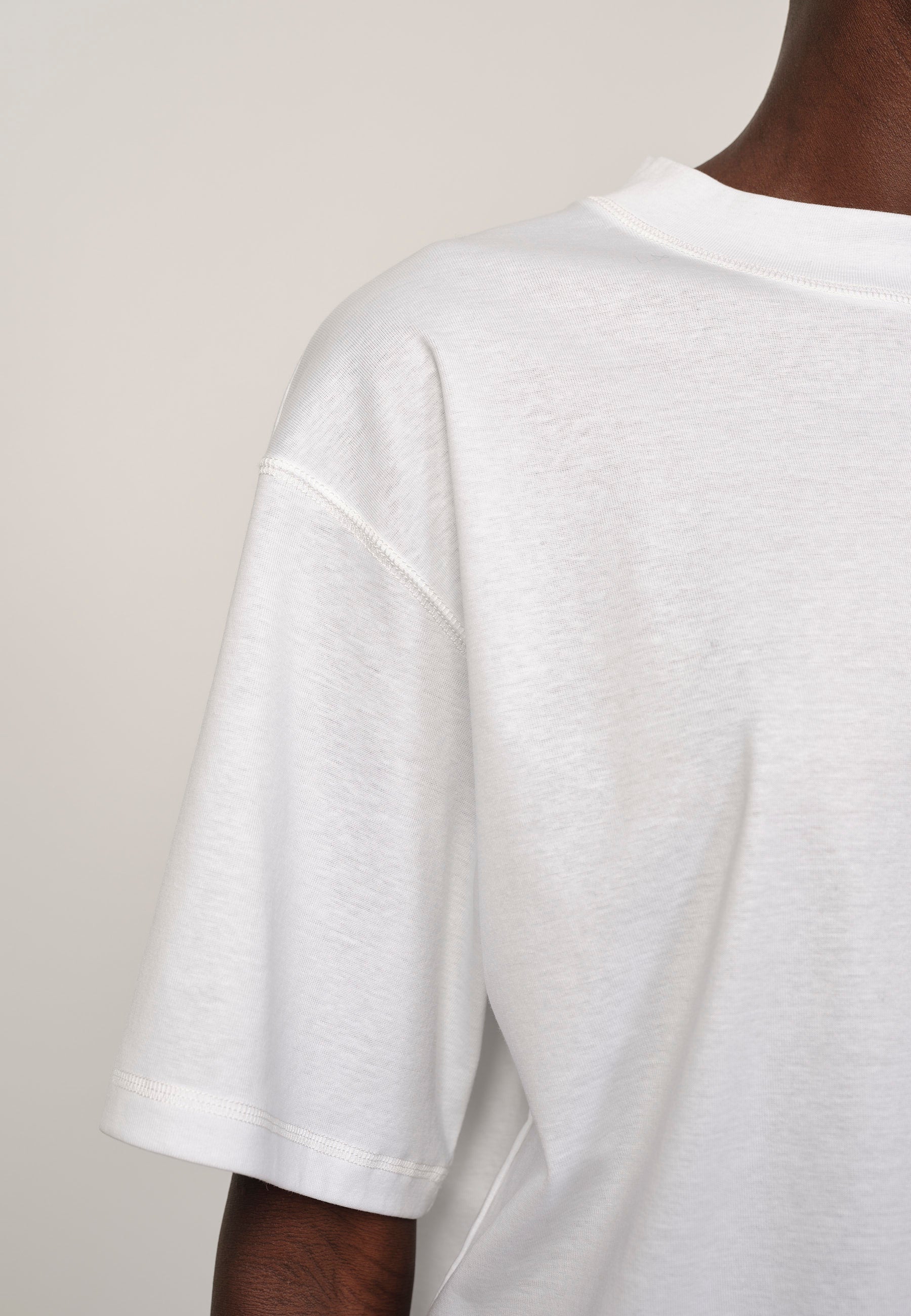White t-shirt worn by a person on a plain background