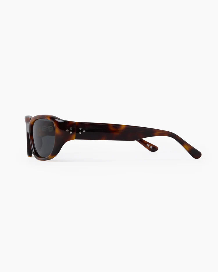 Sunglasses with tortoiseshell frame and dark lenses on a white background