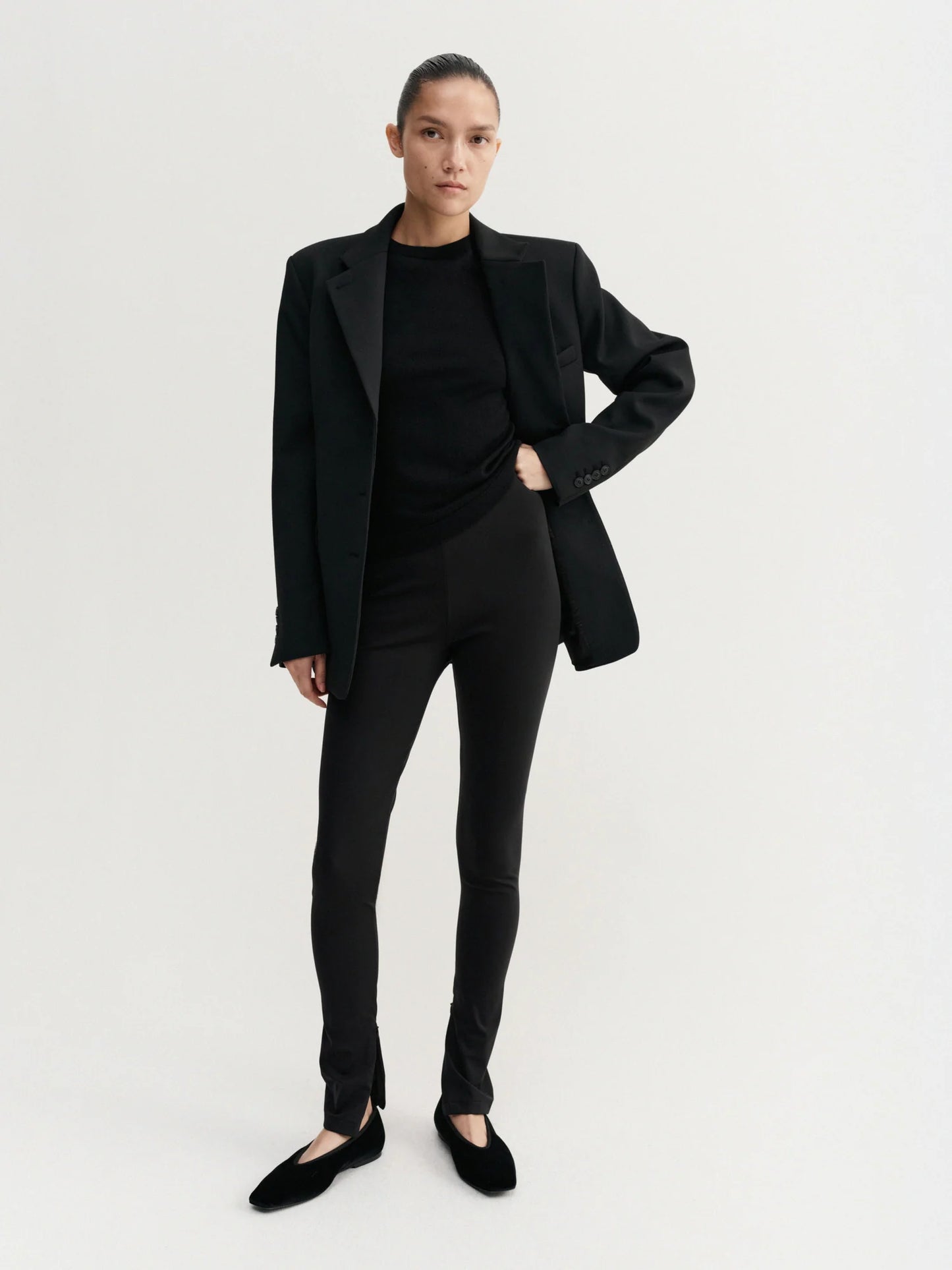 Person wearing a black suit on a white background