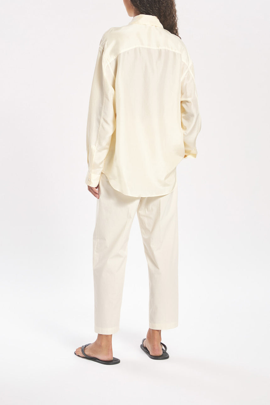 Person wearing a light-colored outfit on a white background