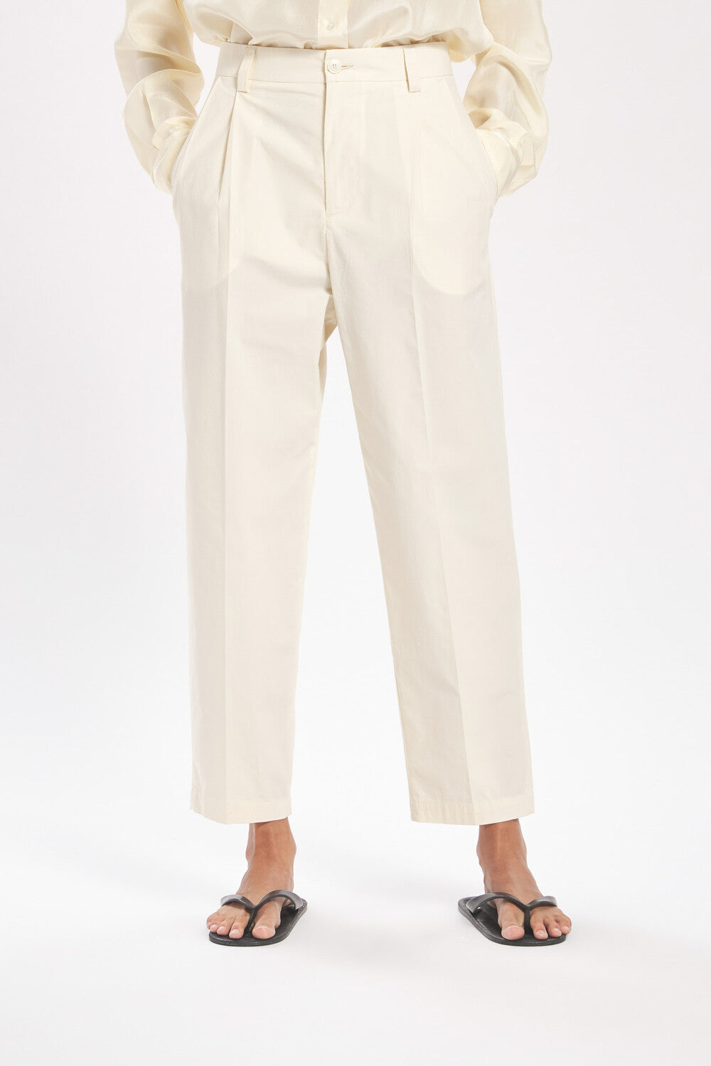 Person wearing cream-colored pants on a white background