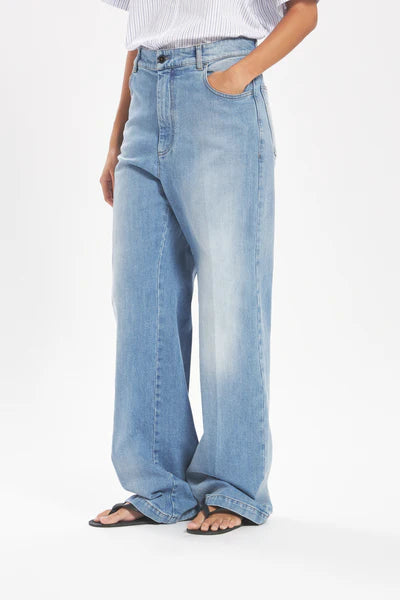Person wearing light blue jeans on a white background
