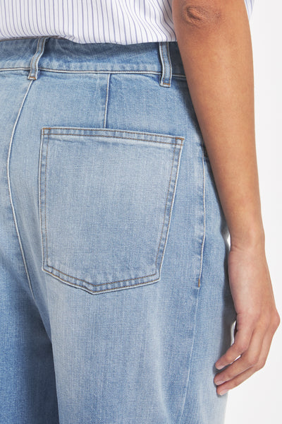 Close-up of light blue jeans with a pocket, worn by a person.