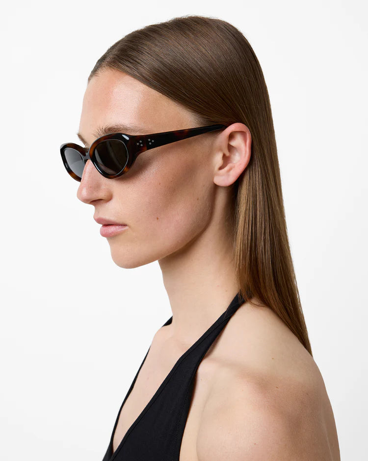 Woman wearing black sunglasses with a plain background