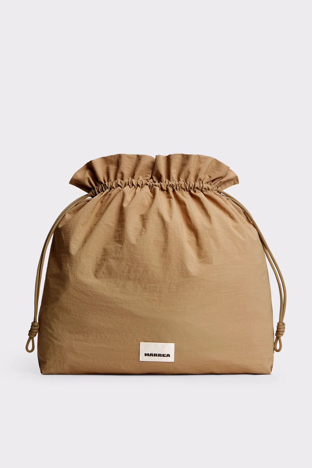 A tan drawstring pouch with a gathered top and a small white rectangular label reading 'MURMIL' near the bottom front, photographed on a light gray background.