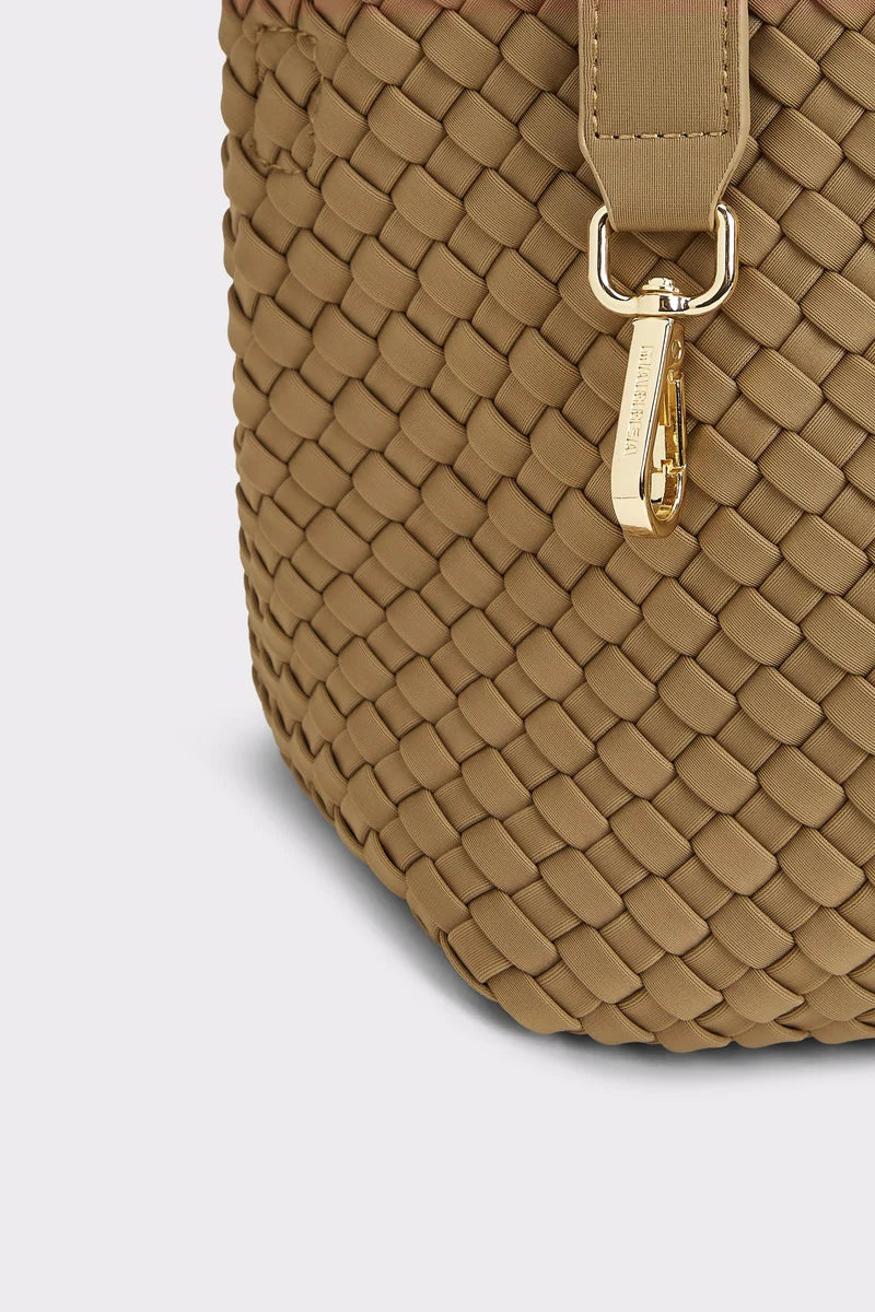 Close-up of a woven leather handbag in tan with a gold-tone metal clasp and strap attachment, shown on a light gray background.