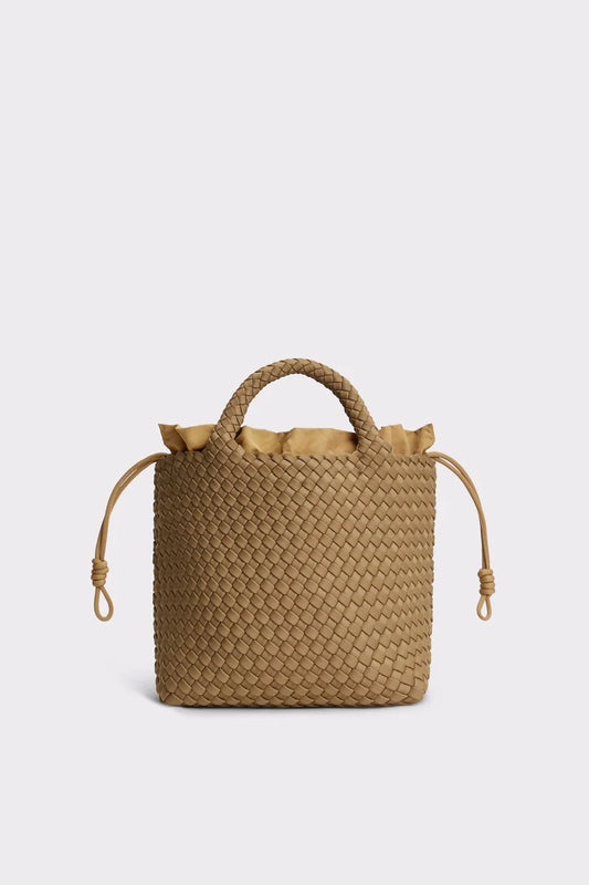 A woven straw bucket bag in a natural tan color, featuring a top handle, drawstring ties, and a ruffled trim at the top, shown against a light gray background.