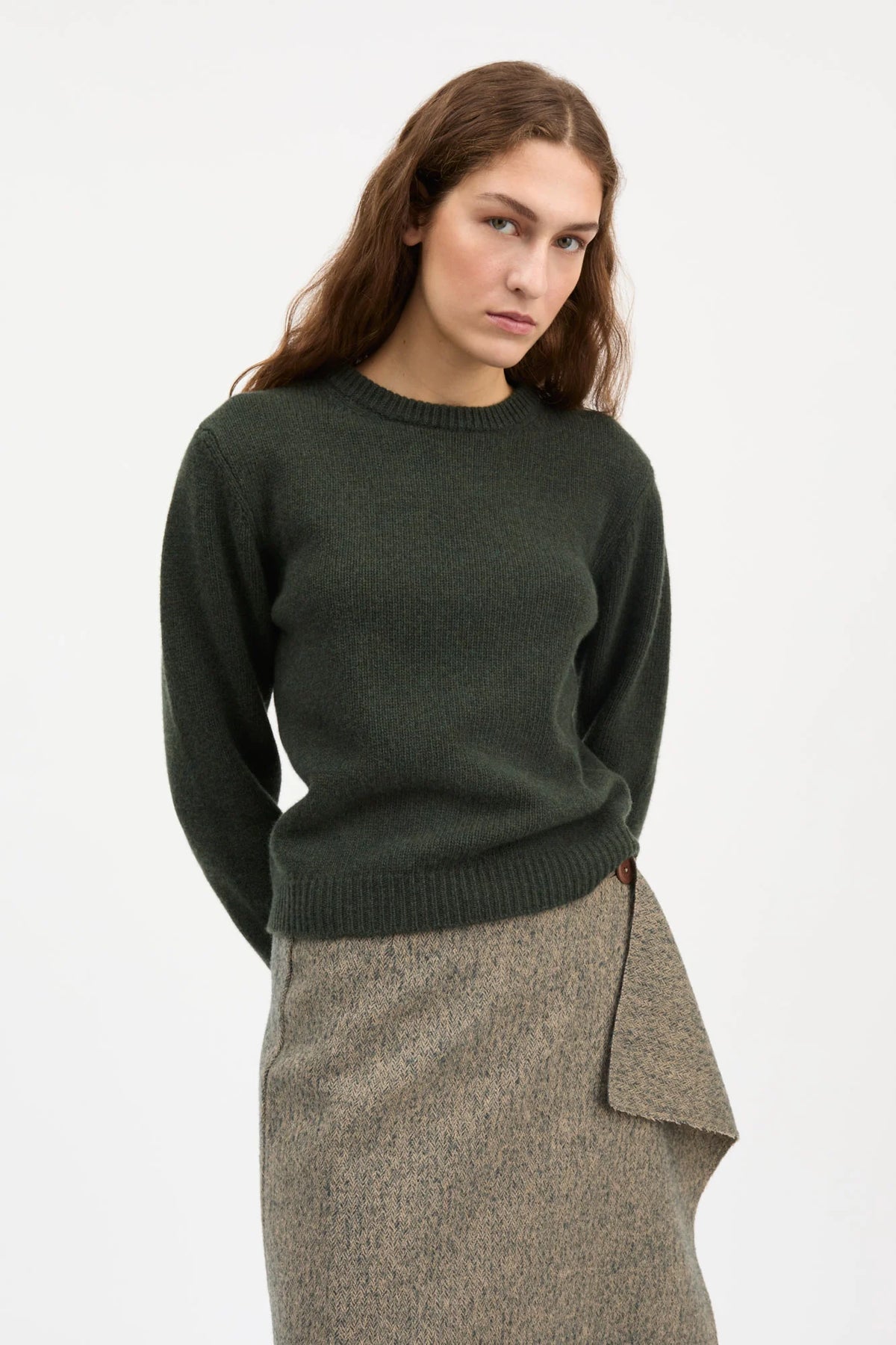 A dark forest green knit crewneck sweater with long sleeves