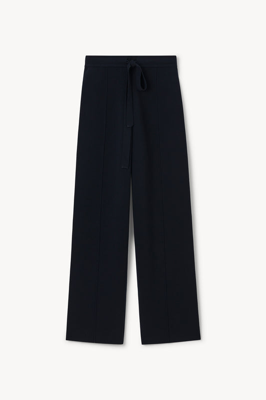 A pair of dark navy wide-leg trousers with a matching fabric drawstring waist, displayed flat against a clean off-white background.