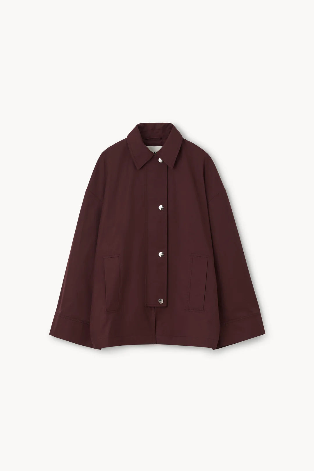 A light gray studio background with a dark burgundy cape-style jacket with wide draped sleeves,