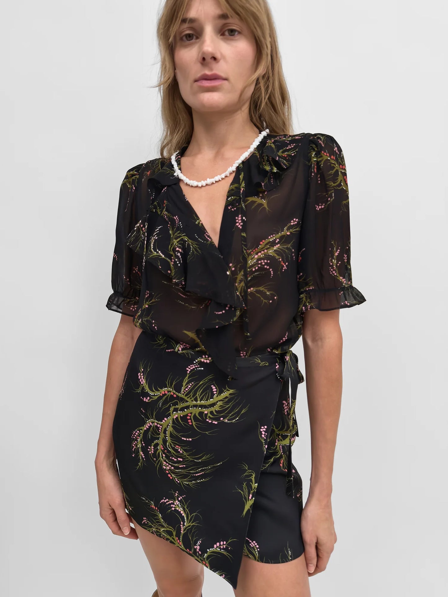 Woman wearing a black floral dress with a white background