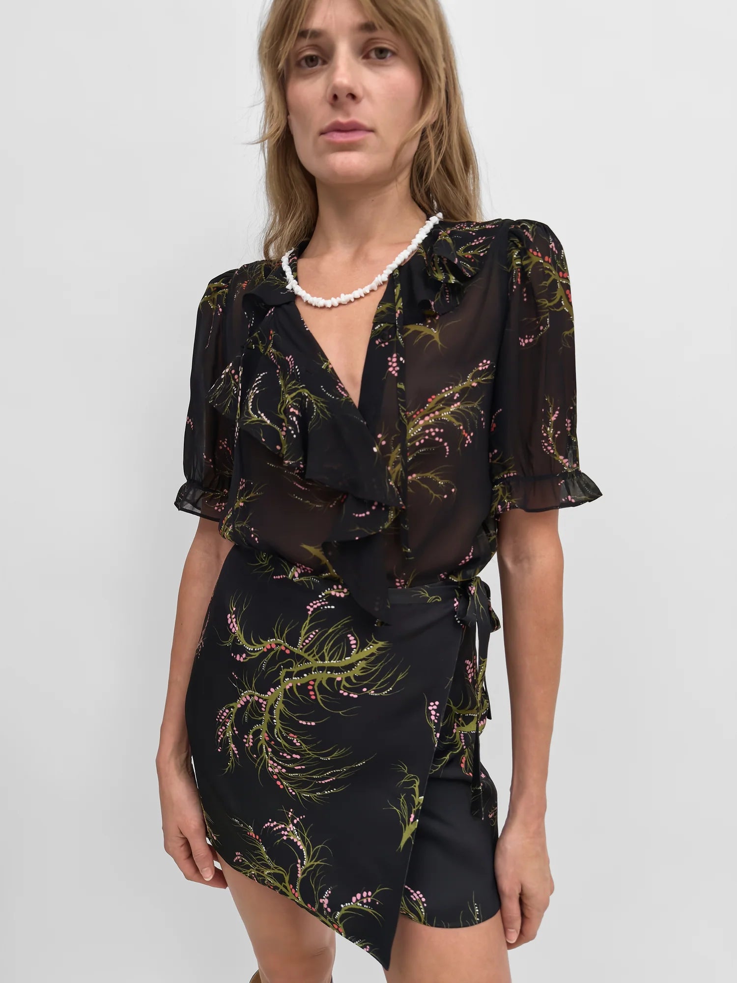 Woman wearing a black floral dress with a white background