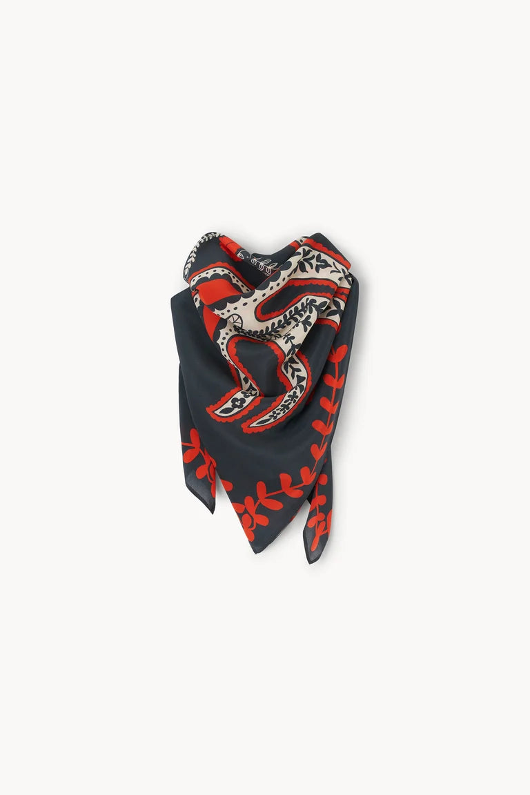 A folded black silk scarf featuring a red and beige botanical and abstract pattern, displayed on a clean off-white background.