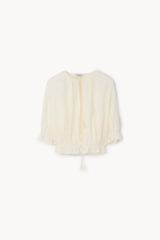 Cream-colored blouse with a subtle pattern on a white background