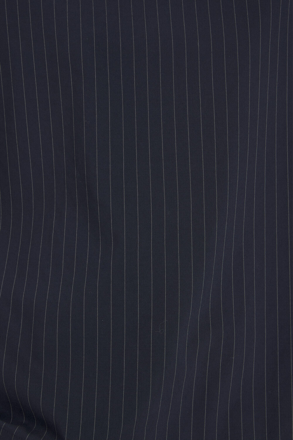 A close-up of dark navy blue fabric with thin, evenly spaced vertical white pinstripes.
