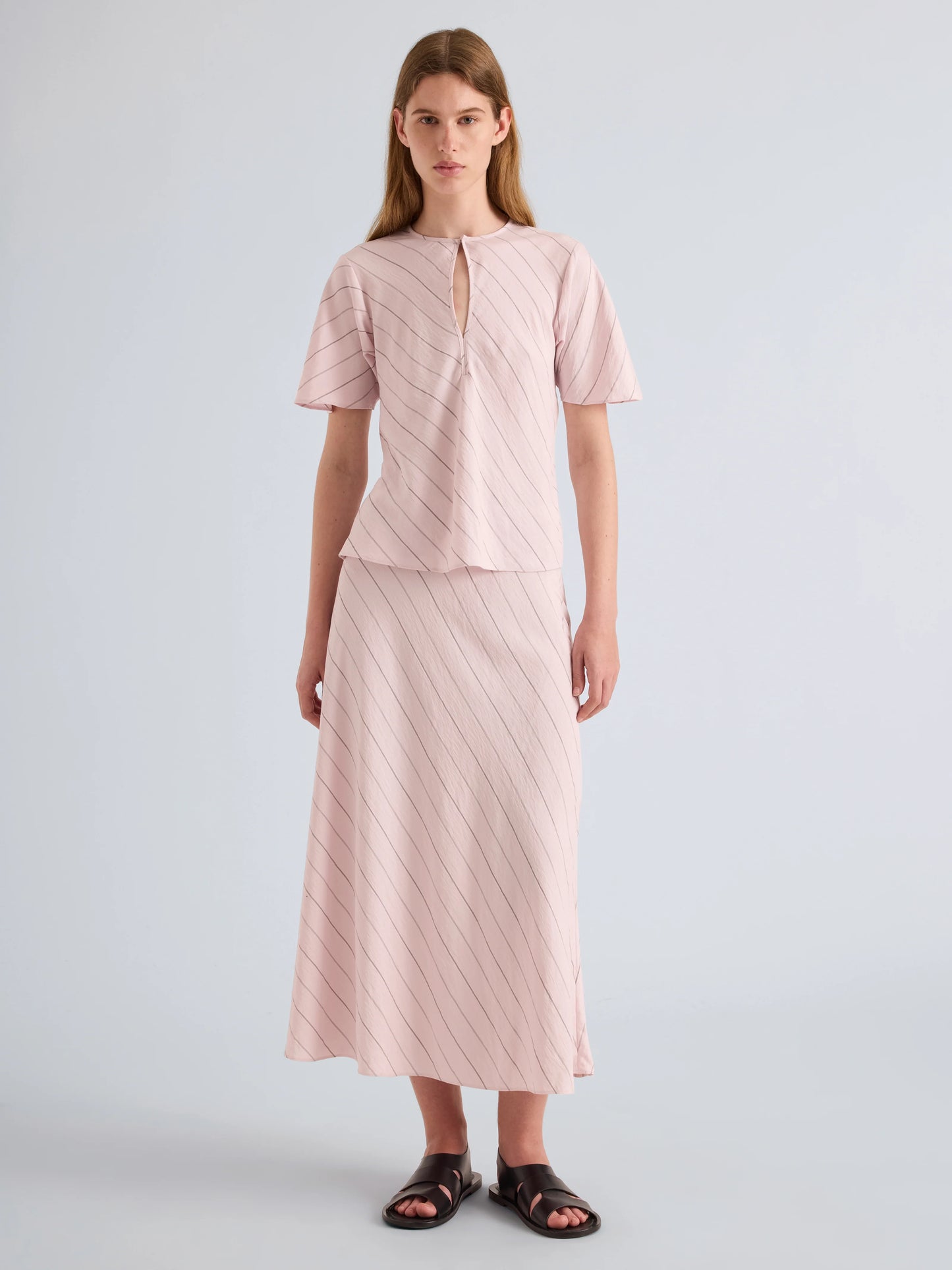 Woman wearing a pink outfit with a plain background