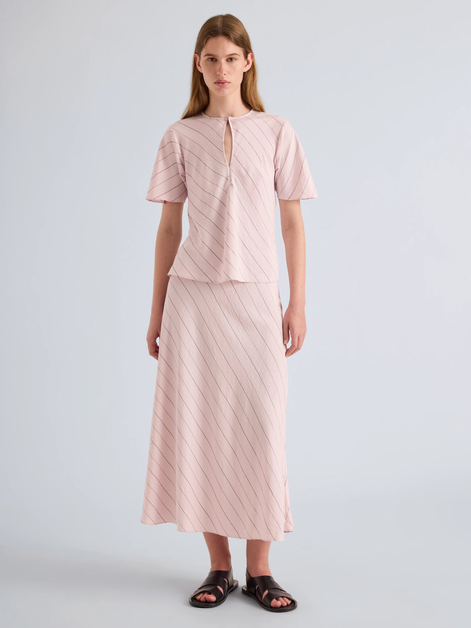 Woman wearing a pink outfit with a plain background