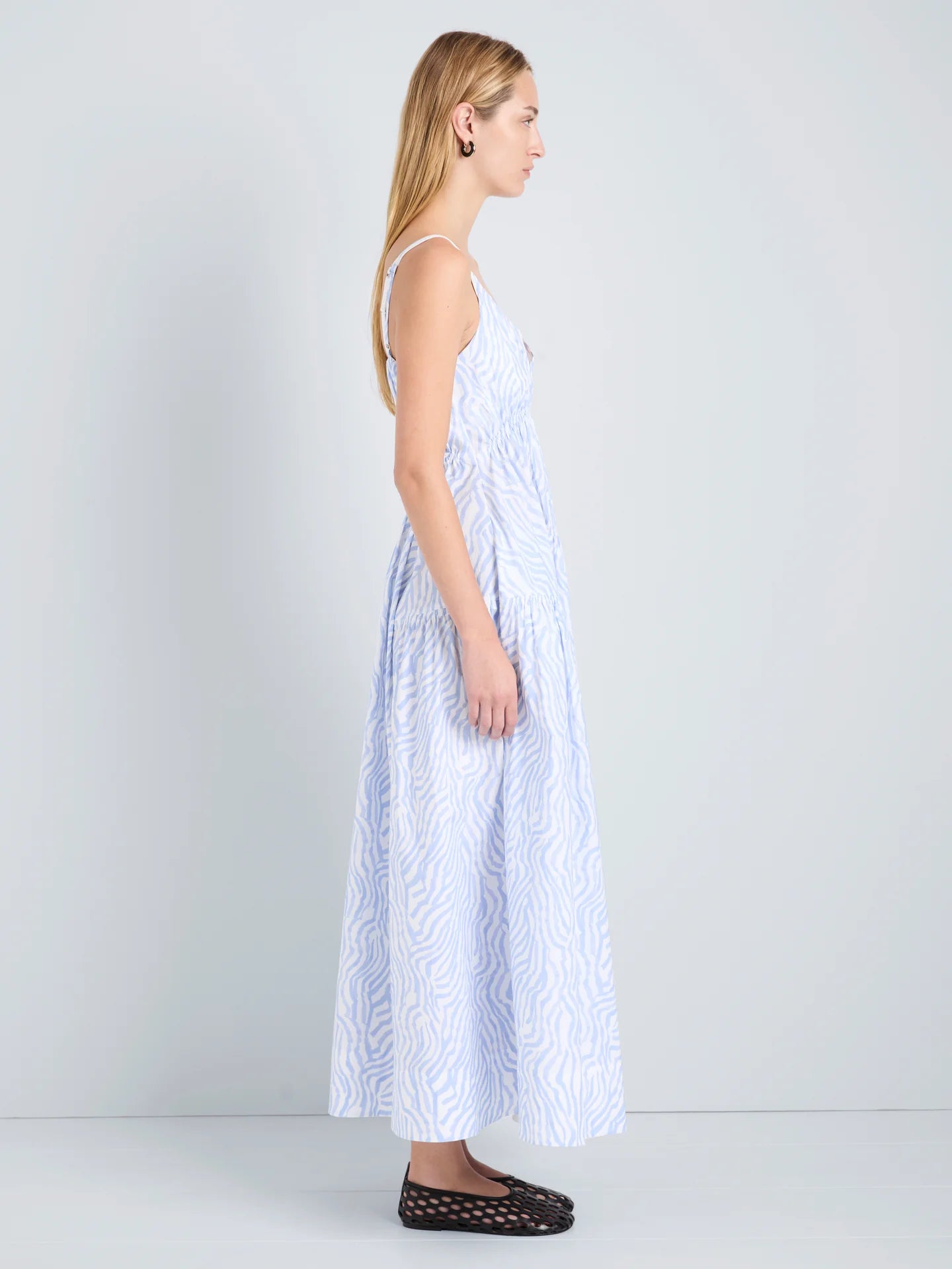 Woman wearing a light blue patterned dress on a white background