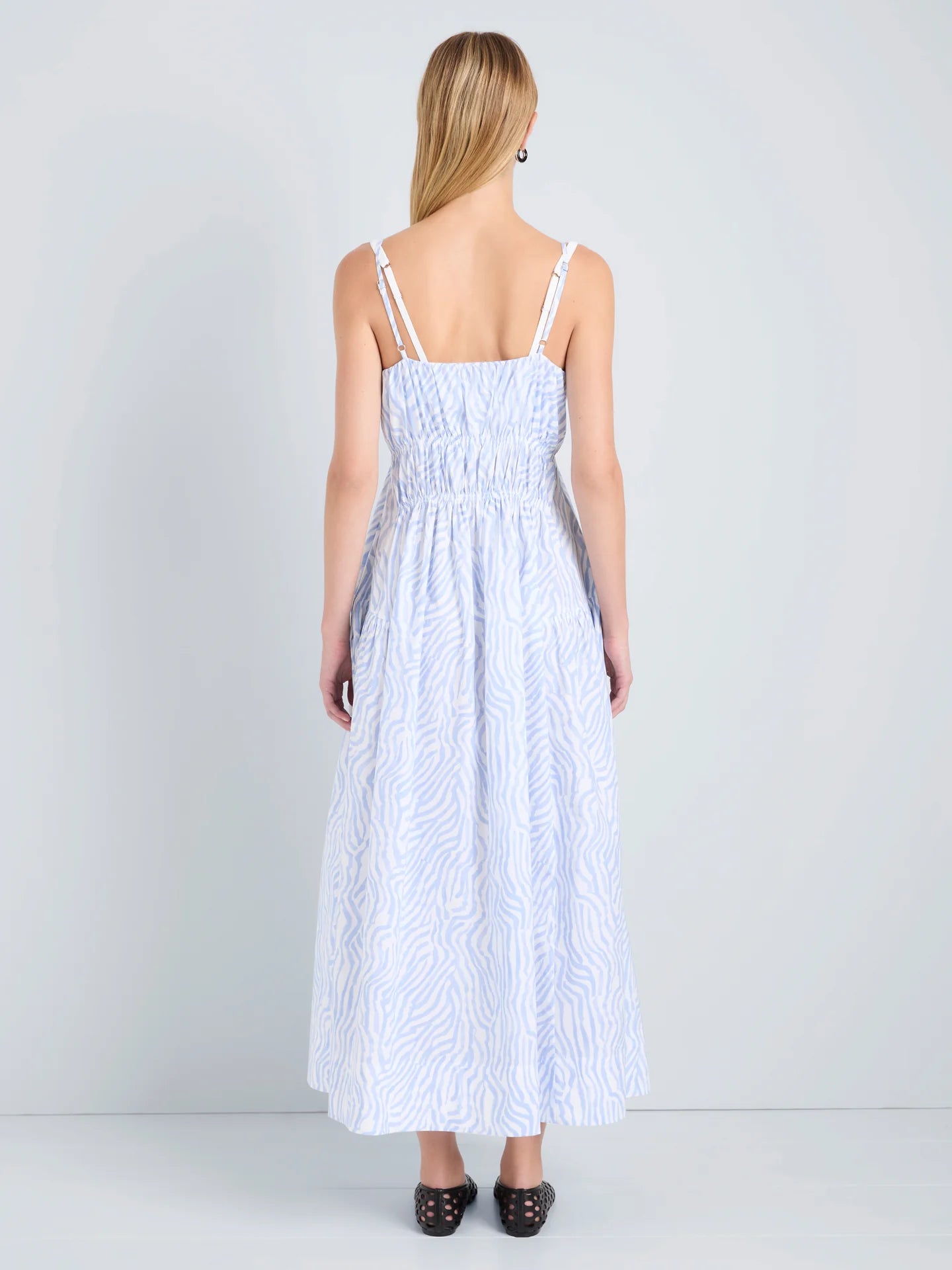 Woman wearing a light blue striped dress against a white background