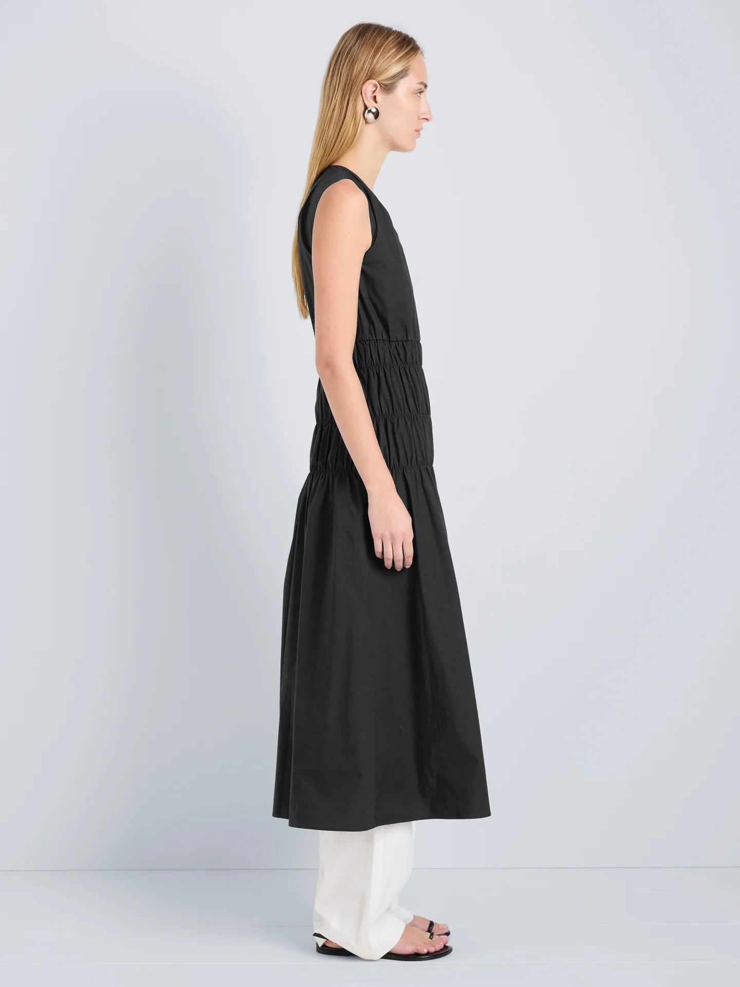 Woman wearing a black sleeveless dress on a gray background