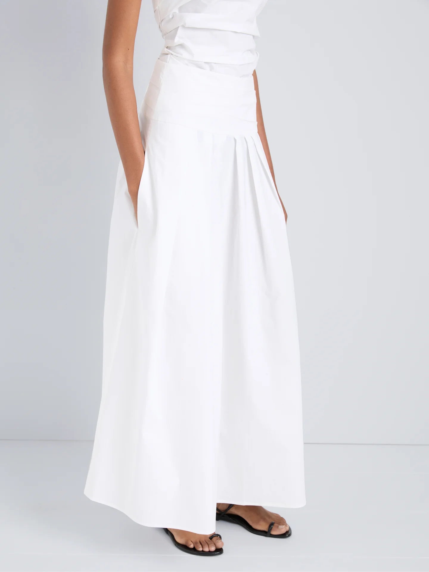 White dress with a slit on a plain background