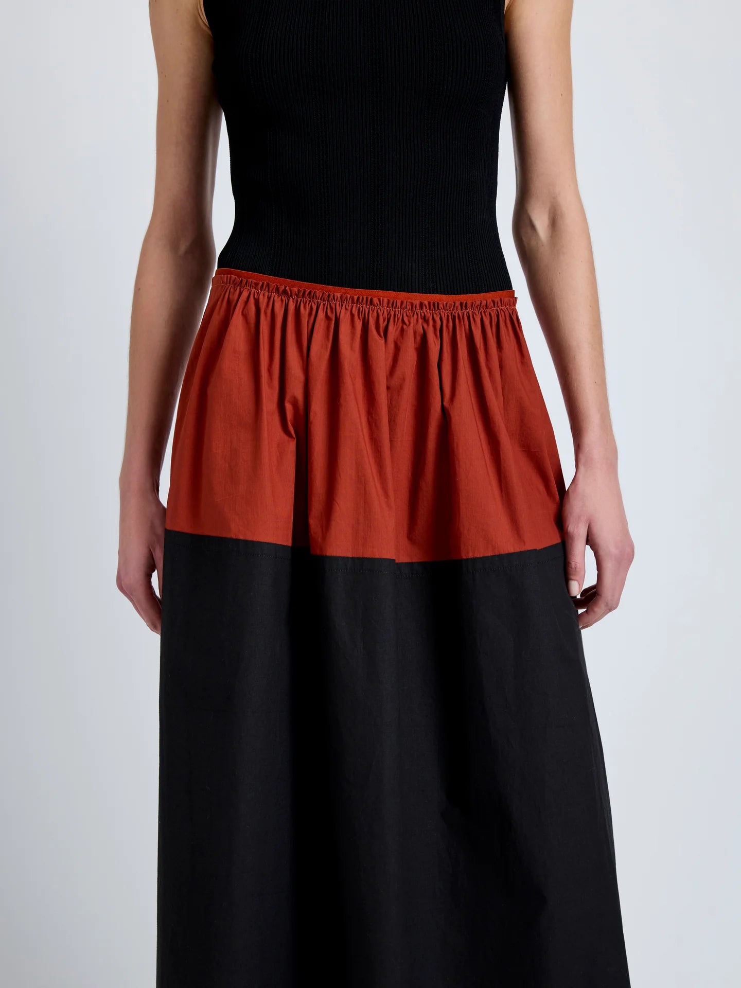 Person wearing a black and red skirt on a white background