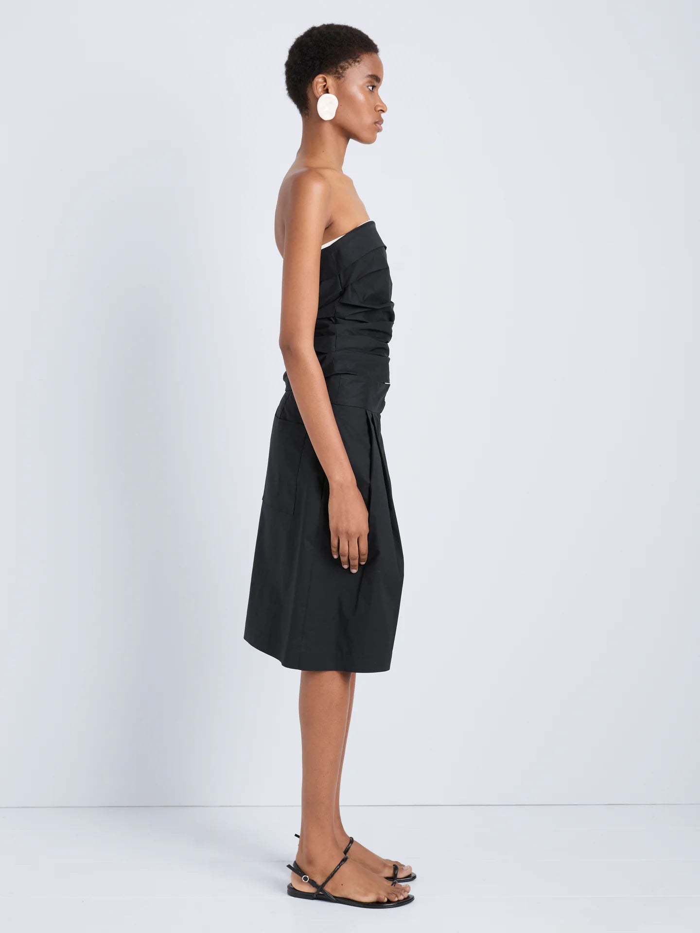 Woman wearing a black strapless dress on a white background
