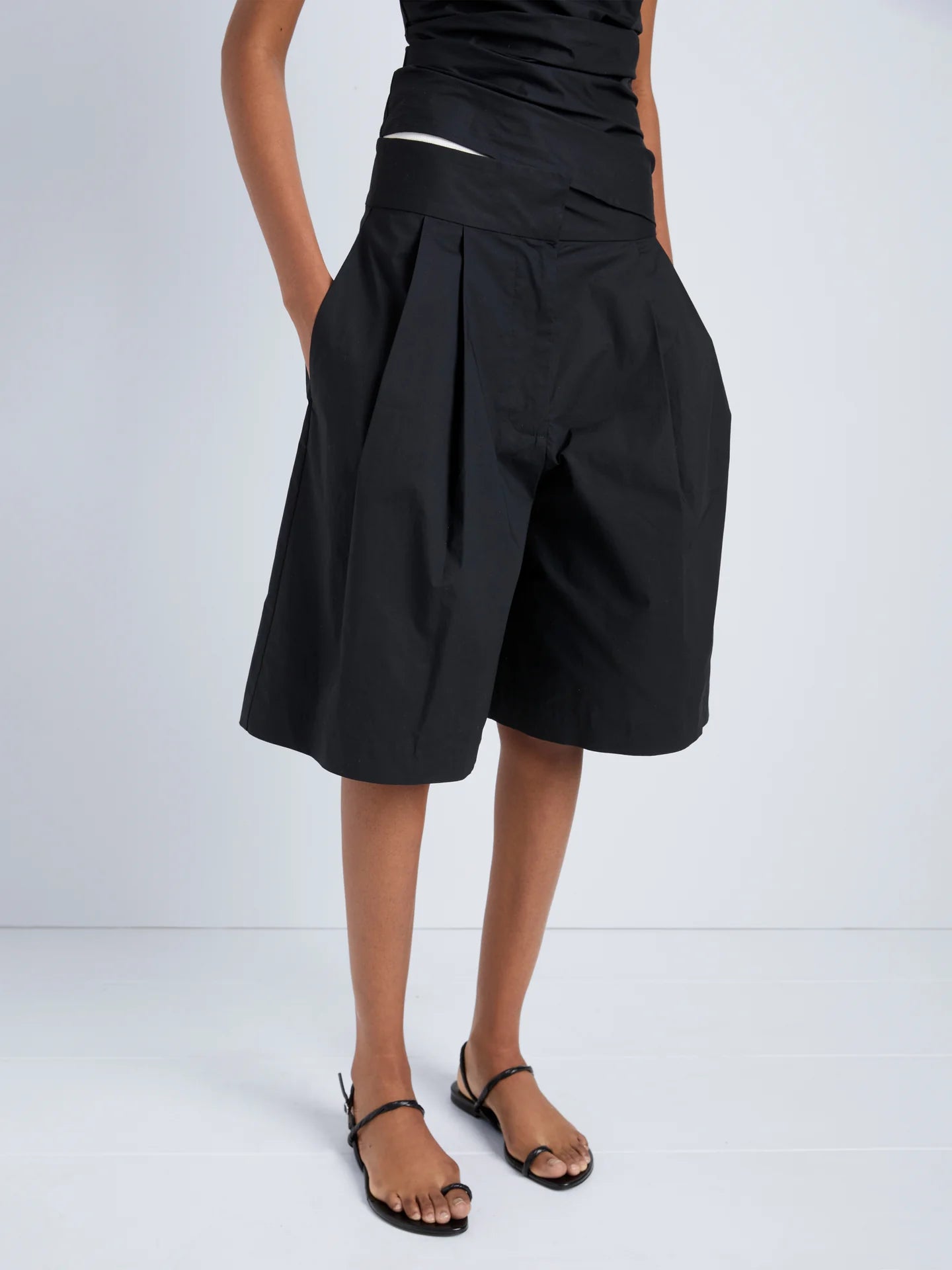 Person wearing a black skirt on a plain background