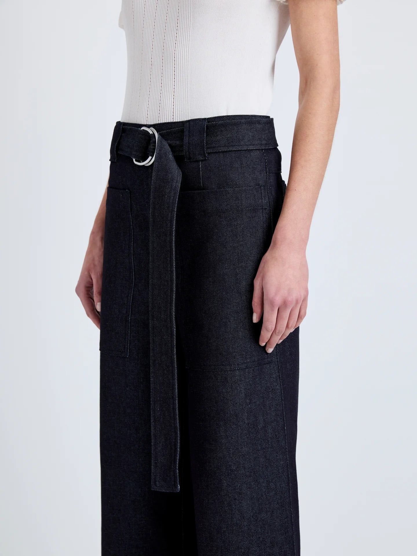 Black wide-leg pants with a belt worn by a person on a white background