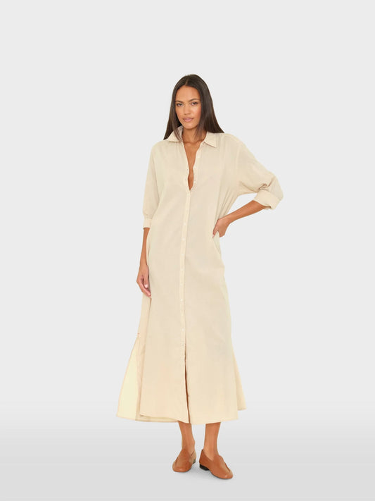 Woman wearing a long beige dress on a white background