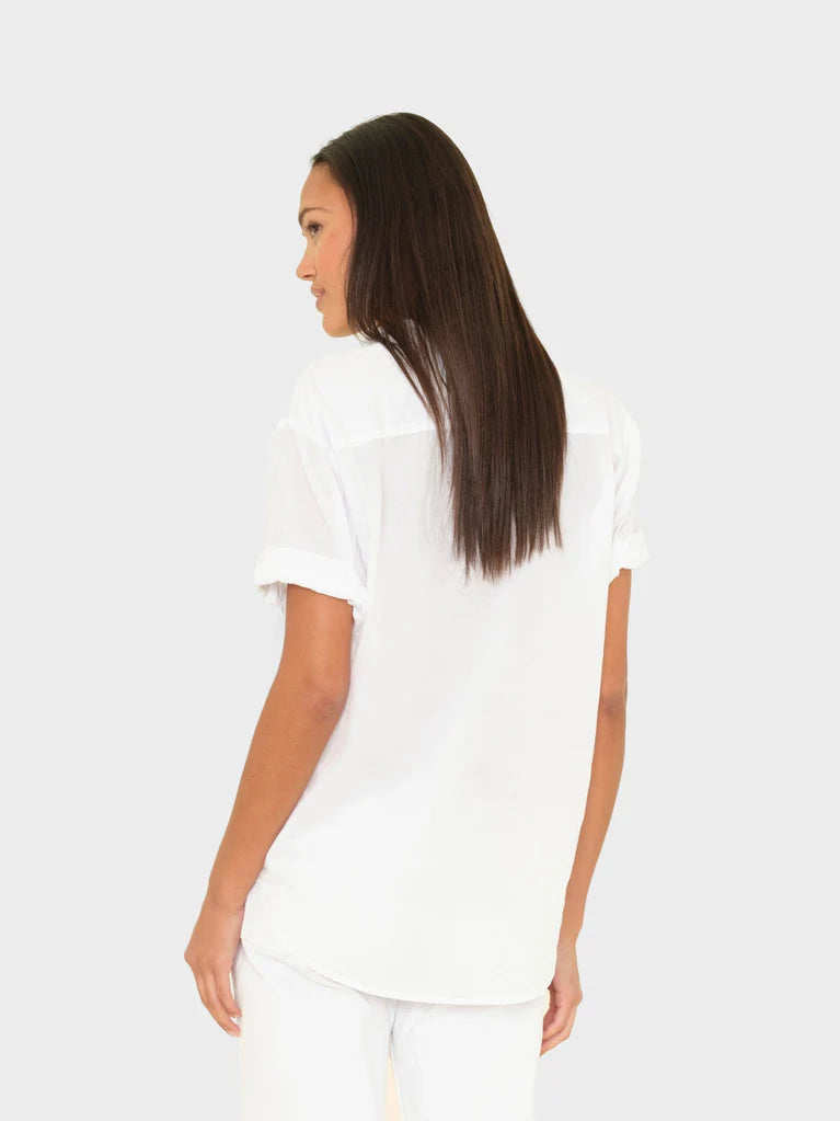 Woman wearing a white t-shirt and pants on a beige background