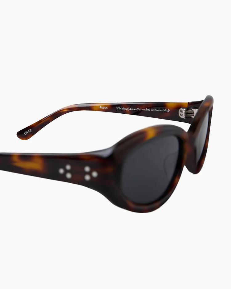 Sunglasses with tortoiseshell frame and dark lenses on a white background