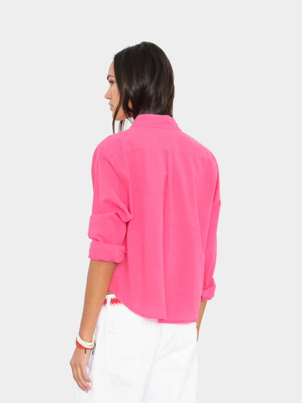 Woman wearing a bright pink shirt on a white background